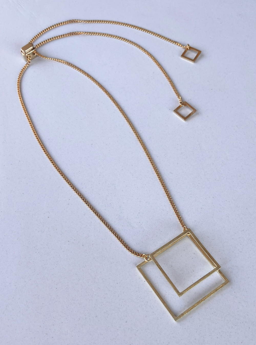 Collana geometrica QUADRATO artigianale in ottone con rifinitura in oro chiaro satinato catena regolabile con cursore e ciondolo realizzato a mano con doppio quadrato effetto tridimensionale. Gioielli contemporanei, gioielli scultura