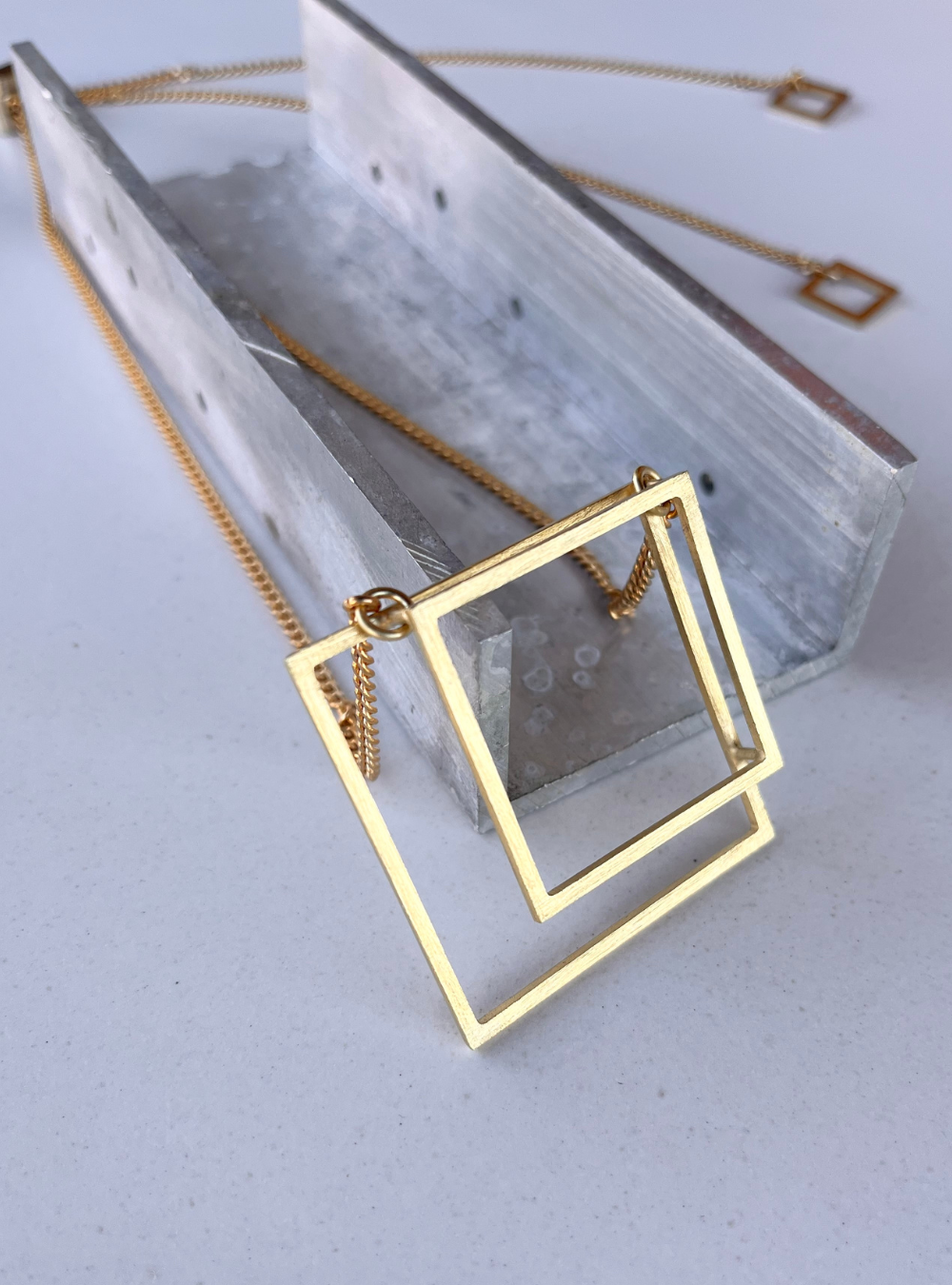Collana geometrica QUADRATO artigianale in ottone con rifinitura in oro chiaro satinato catena regolabile con cursore e ciondolo realizzato a mano con doppio quadrato effetto tridimensionale. Gioielli contemporanei, gioielli scultura