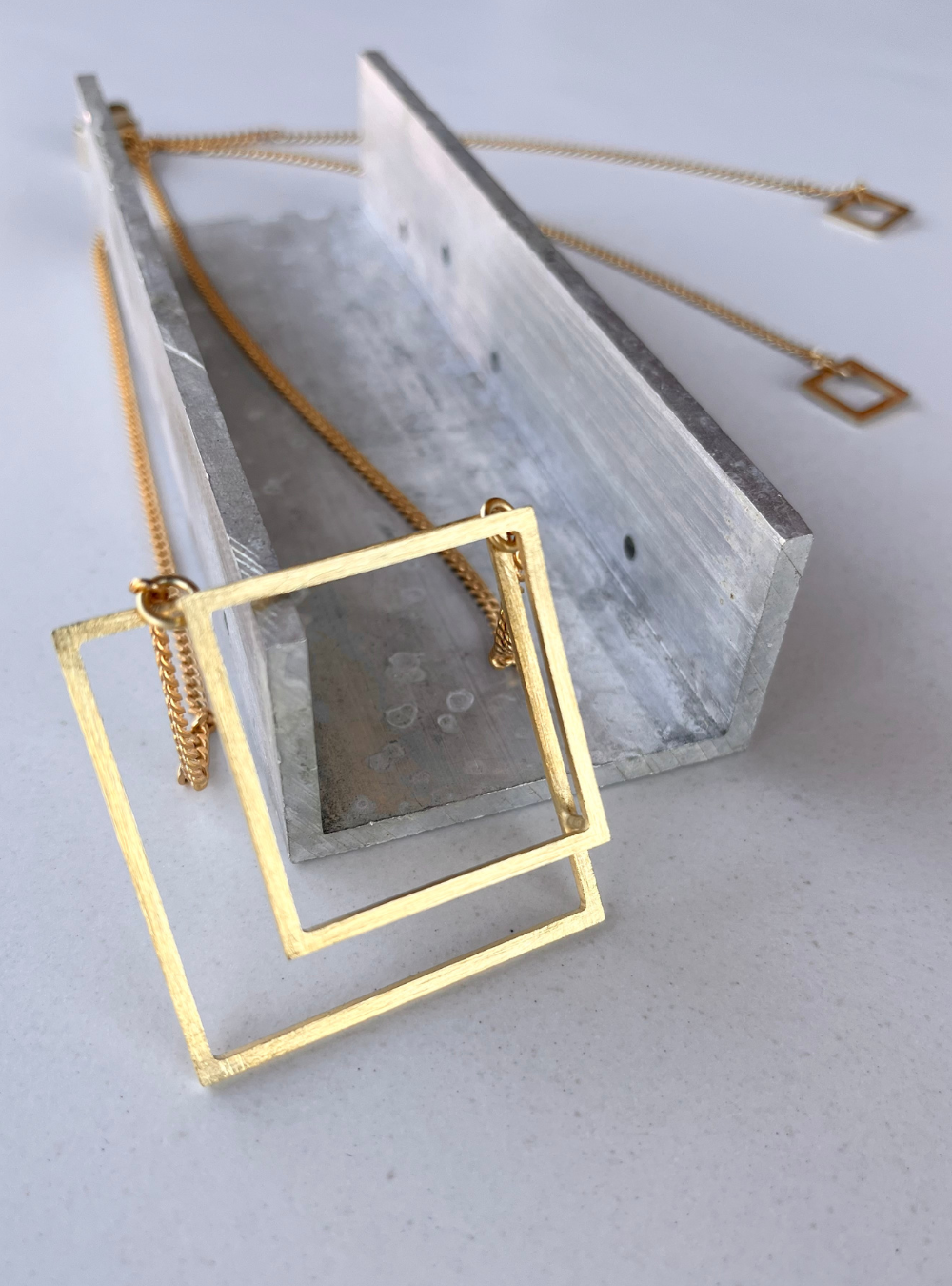 Collana geometrica QUADRATO artigianale in ottone con rifinitura in oro chiaro satinato catena regolabile con cursore e ciondolo realizzato a mano con doppio quadrato effetto tridimensionale. Gioielli contemporanei, gioielli scultura