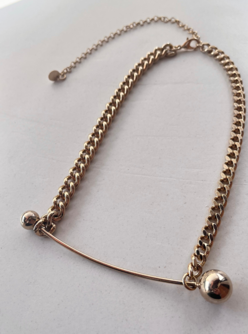 Collana geometrica linea PIERCING in ottone con rifinitura in oro chiaro lucido catene diverse e regolazione con moschettone nella parte dietro con ciondolo 10 cm costruito in filo con sfere asimmetriche che oscilla leggermente al movimento del collo