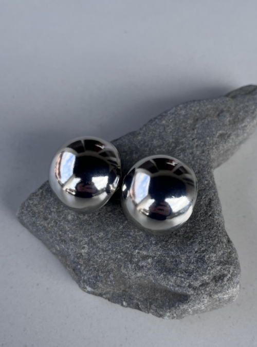 Orecchini geometrici a sfera in ottone con finitura in argento lucido, diametro 1,5 cm, leggeri e con chiusura a perno e farfallina, design minimalista e moderno."
