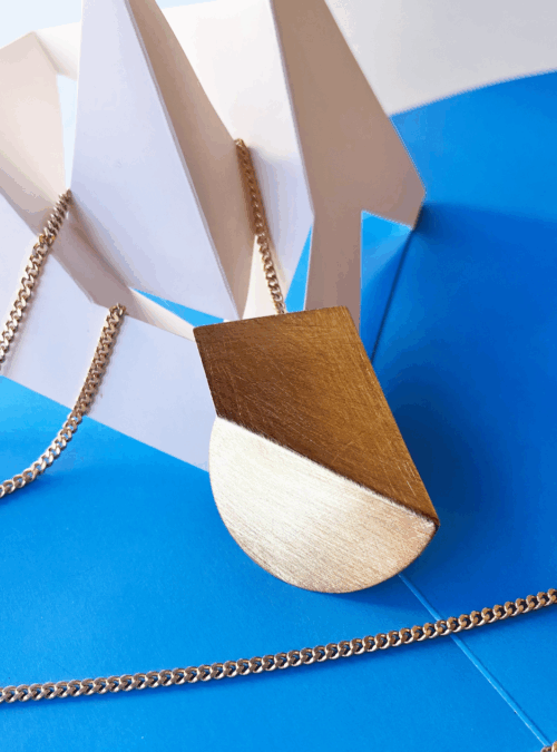 Collana geometrica EQUILIBRIO MINIMO artigianale in ottone con centrale in lamina di ottone piegata con rifinitura in oro chiaro satinato catena a lunghezza regolabile grazie al cursore con bottone che regola la lunghezza