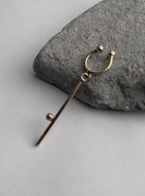 Orecchino EARCUFF short in ottone con rifinitura in oro chiaro lucido composto da un'anellina da regolare al padiglione dell'orecchio e un ciondolo in filo con piccola sfera saldata. Orecchino minimale e leggero da indossare con altri orecchini