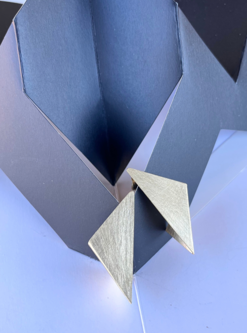 Orecchini geometrici piega e porta in ottone oro chiaro satinato ispirati alle sculture da viaggio di Bruno Munari.